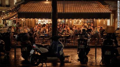 Customers crowd a Parisian cafe Wednesday as the French government announced that from Monday all bars in the city will shut at 10 p.m.