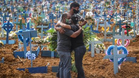 Relatives of a deceased person wearing protective masks mourn during a mass burial of coronavirus (COVID-19) pandemic victims at the Parque Taruma cemetery on May 19, 2020 in Manaus, Brazil. Brazil has over 260,000 confirmed cases and more than 17,000 deaths caused by coronavirus (COVID-19) pandemic.