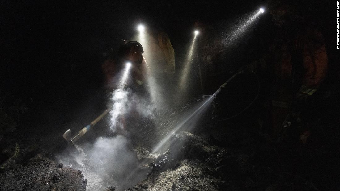 Inmate firefighters extinguish hot spots while working to contain the Bear Fire on September 24.