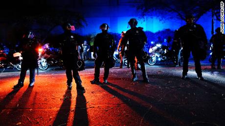 Portland police stand in a street Saturday during protests against systemic racism that started after the police killing of George Floyd in May. 