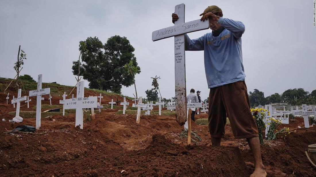 A grave digger in Jakarta, Indonesia, plants a cross in a public cemetery, part of which is reserved for suspected Covid-19 victims, on September 26.