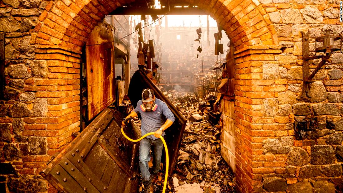 Cellar worker Jose Juan Perez extinguishes hotspots at Castello di Amorosa, a Calistoga winery that was damaged in the 2020 Glass Fire.