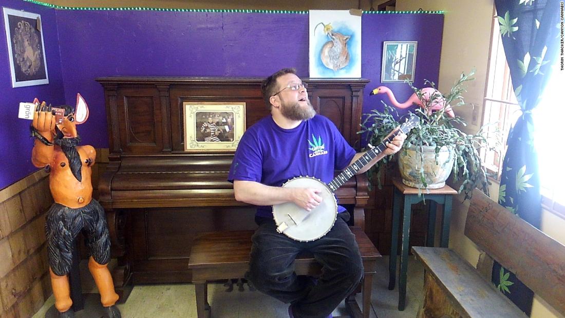 Thorin Thacker, owner of Canyon Cannabis, sings and picks at a banjo on April 11, 2018, at the Gates, Oregon, dispensary. Canyon Cannabis was destroyed by the Beachie Creek Fire on Sept. 8, 2020.