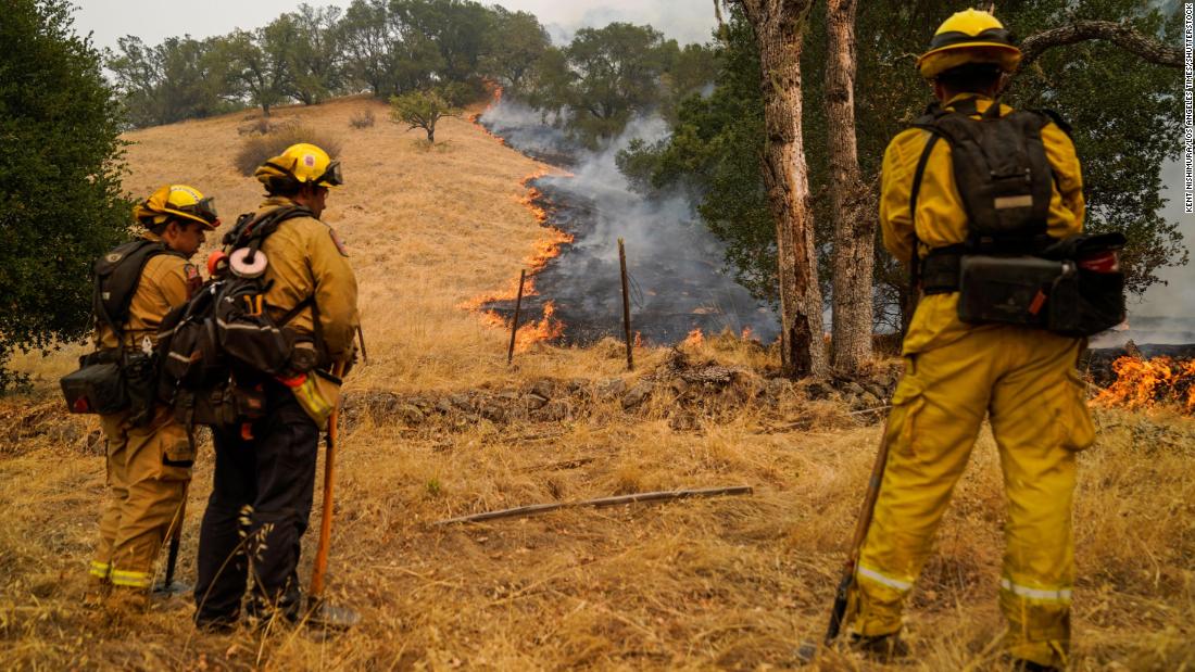 Firefighters watch the Glass Fire slowly creep across a clearing near Calistoga on September 29.