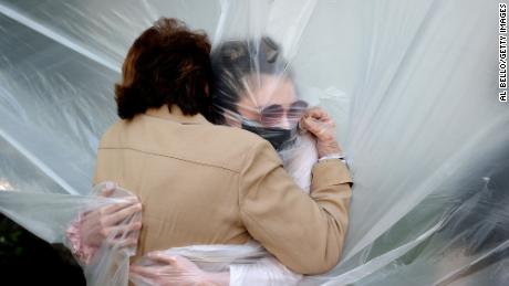 Olivia Grant kisses her grandmother Mary Grace Sileo through a plastic rag in Wantagh, New York.