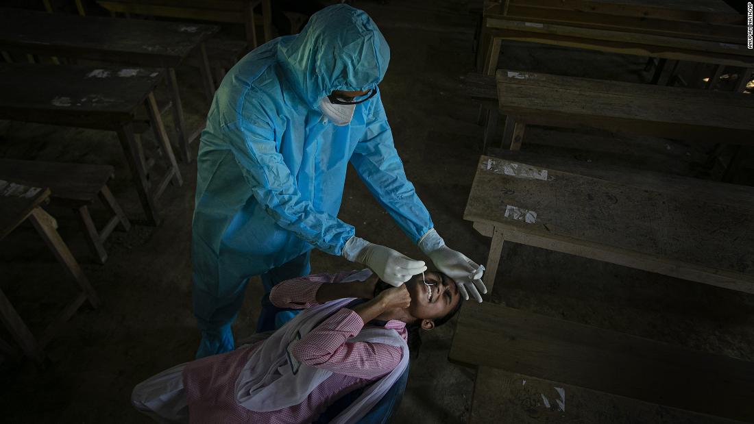 A health worker tests a student for Covid-19 after classes started at a college in the Indian village of Jhargaon on September 30. 