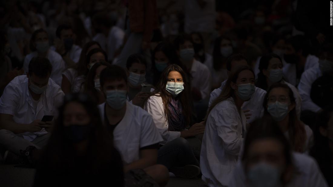 Medical residents sit in the middle of a street as they protest their working conditions in Barcelona, Spain, on September 28.