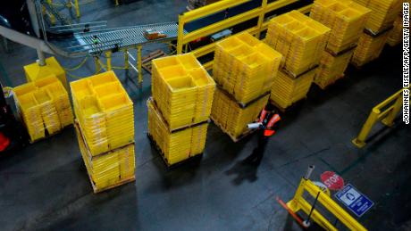 A man works at a distrubiton station at the 855,000-square-foot Amazon fulfillment center in Staten Island, one of the five boroughs of New York City, on February 5, 2019. - Inside a huge warehouse on Staten Island thousands of robots are busy distributing thousands of items sold by the giant of online sales, Amazon. (Photo by Johannes EISELE / AFP)        (Photo credit should read JOHANNES EISELE/AFP via Getty Images)