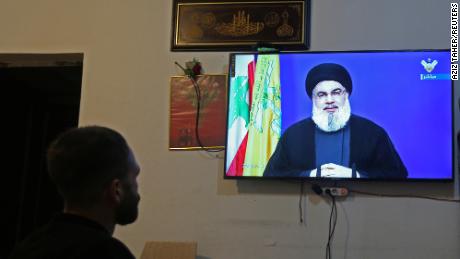 A man watches Lebanon&#39;s Hezbollah leader Sayyed Hassan Nasrallah speaking on television, inside a shop in Houla, southern Lebanon on September 29, 2020. 