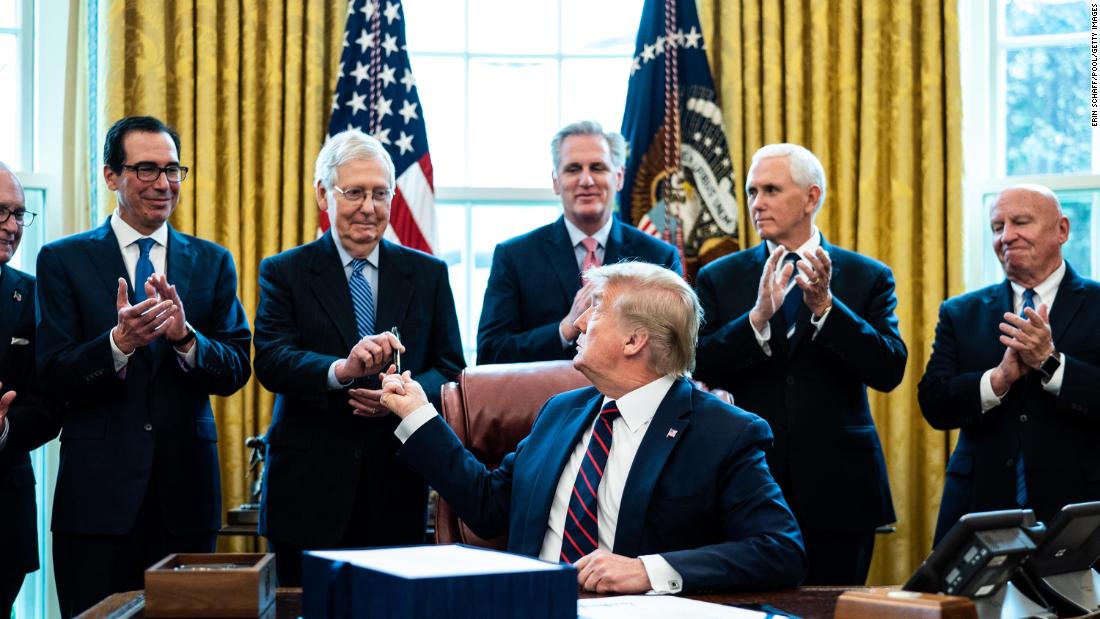 Trump hands a pen to Senate Majority Leader Mitch McConnell during a bill-signing ceremony for the Coronavirus Aid, Relief and Economic Security Act in March 2020.
