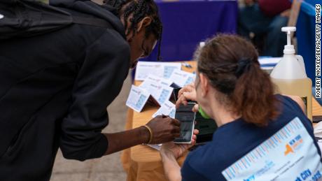  A volunteer from Brooklyn Voters Alliance (R) assists a person as he fills out an online census form September 27, 2020 in New York City. 