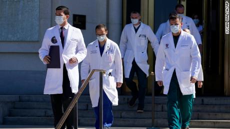 Dr. Sean Conley, physician to President Donald Trump, left, walks to brief reporters at Walter Reed National Military Medical Center in Bethesda, Md., Saturday, Oct. 3, 2020. Trump was admitted to the hospital after contracting the coronavirus. (AP Photo/Susan Walsh)