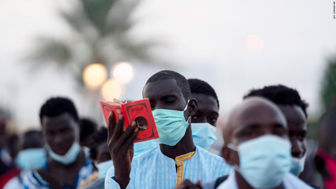 A man from the Mouride Brotherhood reads a book with poems written by Cheikh Amadou Bamba as he stands in line to enter the Grand Mosque of Touba in Touba, Senegal, on October 5. 