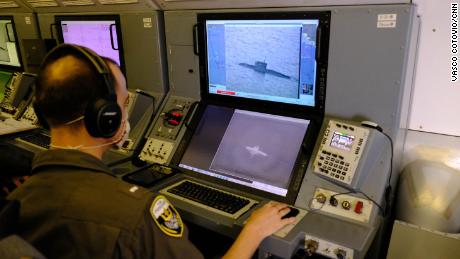 A US Navy service member uses the P-8A&#39;s camera to track track a Russian Kilo-class submarine as it sails through the Black Sea.