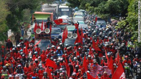 Workers block a road during a strike against a government omnibus bill on job creation which they believe will deprive workers of their rights, in Bandung on October 6, 2020.