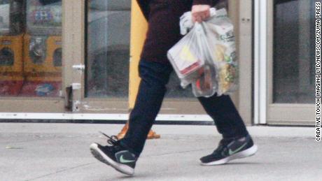 A woman in Toronto carries her groceries in plastic bags on April 24, 2020.