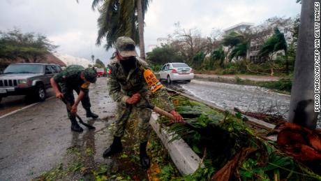 A tourist speaks on his phone Wednesday outside a shelter after the passage of Hurricane Delta in Cancun, Mexico.