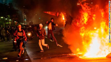 A protester throws a traffic cone onto a fire during Thursday in Jakarta.