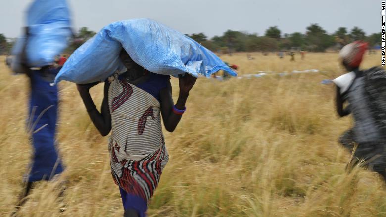 Villagers collect food aid dropped from a World Food Programme plane to a village in Ayod county, South Sudan, in February 2020. 