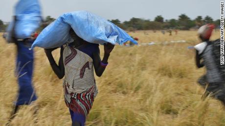 Villagers collect food aid dropped from a World Food Programme plane to a village in Ayod county, South Sudan, in February 2020. 