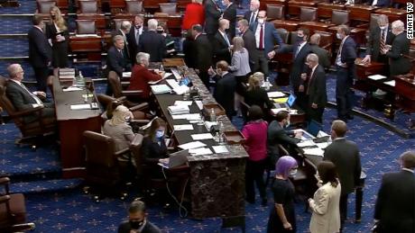 North Dakota Sen. Kevin Cramer, far left, presides over the Senate on September 30, while senators, including those who have since tested positive for coronavirus, huddle close together on the floor. Majority Leader Mitch McConnell is at far right. 