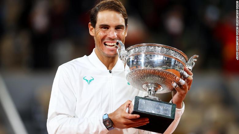 Rafael Nadal bites the winning trophy after claiming the French Open title for the 13th time  time with a straight sets victory over Novak Djokovic.