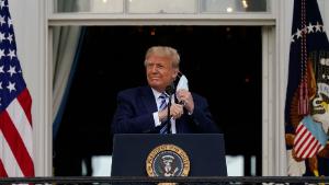 President Donald Trump removes his face mask to speak from the Blue Room Balcony of the White House to a crowd of supporters, Saturday, Oct. 10, 2020, in Washington. (AP Photo/Alex Brandon)