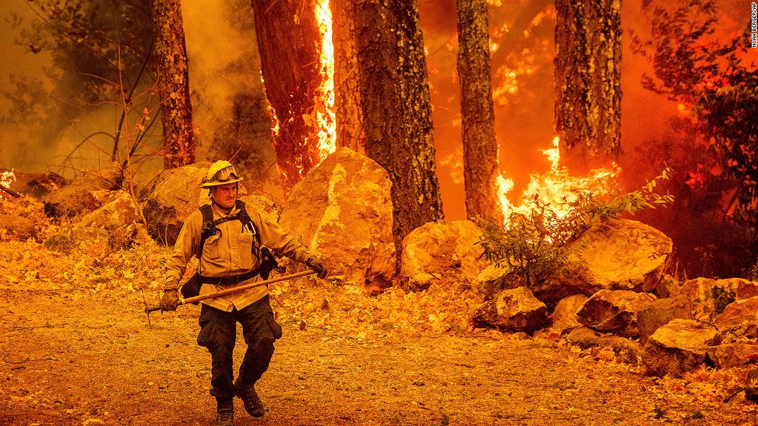 A firefighter walks along a path as the Glass Fire burns in Calistoga, California, on October 1.