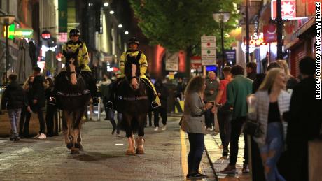 Police patrol as revelers enjoy a night out in the center of Liverpool, northwest England on Saturday, ahead of strict new measures planned in the area.