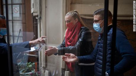 Customers receive hand sanitizer at the Chartier Bouillon Restaurant in Paris on Saturday. 