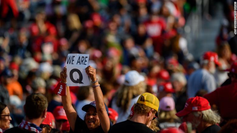 A woman holds up a QAnon sign to the media as attendees wait for President Donald Trump to speak at a campaign rally at Atlantic Aviation on September 22 in Moon Township, Pennsylvania. 