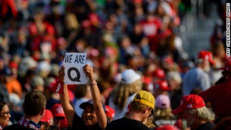 A woman holds up a QAnon sign to the media as attendees wait for President Donald Trump to speak at a campaign rally at Atlantic Aviation on September 22 in Moon Township, Pennsylvania. 