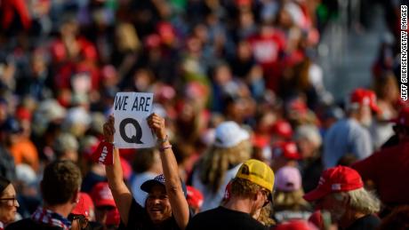 MOON TOWNSHIP, PA - SEPTEMBER 22: A woman holds up a QAnon sign to the media as attendees wait for President Donald Trump to speak at a campaign rally at Atlantic Aviation on September 22, 2020 in Moon Township, Pennsylvania. Trump won Pennsylvania by less than a percentage point in 2016 and is currently in a tight race with Democratic nominee, former Vice President Joe Biden. (Photo by Jeff Swensen/Getty Images)