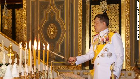 Le roi thaïlandais Maha Vajiralongkorn allume des bougies alors qu'il participe à une cérémonie bouddhiste pour marquer le festival Kathina 2020 au Wat Ratchabophit à Bangkok le 10 octobre 2020.