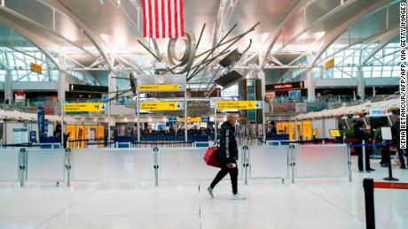 A man walks past counters at the Terminal 1 section at John F. Kennedy International Airport on March 12, 2020 in New York City. - US President Donald Trump announced a shock 30-day ban on travel from mainland Europe over the coronavirus pandemic that has sparked unprecedented lockdowns, widespread panic and another financial market meltdown Thursday.The announcement came as China, where the outbreak that first emerged in December, showed a dramatic drop in new cases and claimed &quot;the peak&quot; of the epidemic had passed. (Photo by Kena Betancur / AFP) (Photo by KENA BETANCUR/AFP via Getty Images)