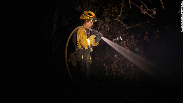 A fire fighter puts out hot spots from the Zogg Fire in Igo.