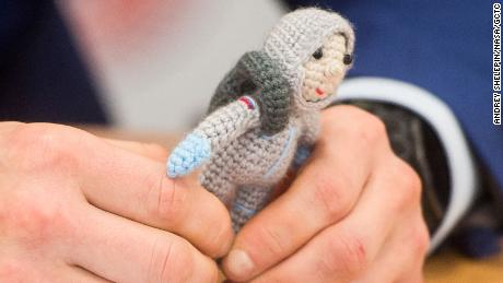 Expedition 64 crew member Sergey Kud-Sverchkov holds a knit cosmonaut named Yuri made by his wife Olga.