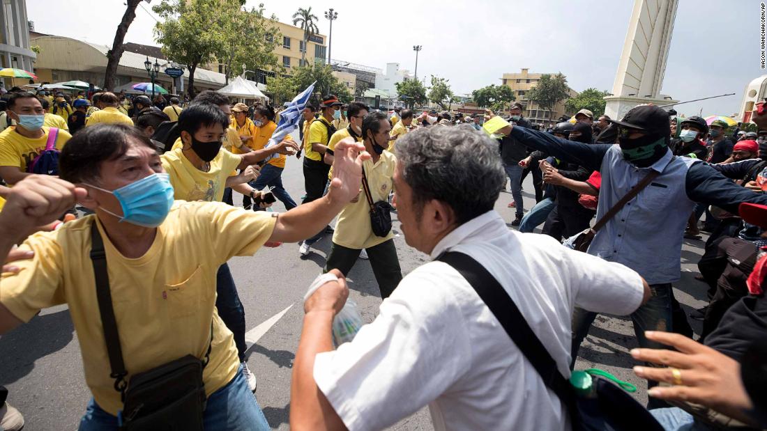A pro-democracy protester, right, and and a supporter of the monarchy, in yellow, exchange blows at a rally near the Democracy Monument in Bangkok on October 14.