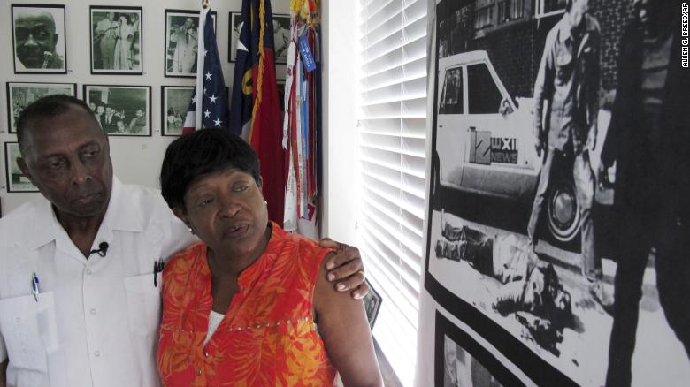 Rev. Nelson Johnson and his wife, Joyce, stand beside a 1979 photo of the Greensboro Massacre.