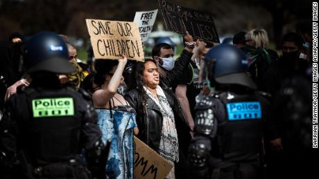 Protestors hold QAnon-related signs during an anti-lockdown demonstration in Melbourne, Australia on September 5th. Some QAnon followers falsely believe the Covid-19 pandemic is an elaborate hoax. (Darrian Traynor/Getty Images AsiaPac)