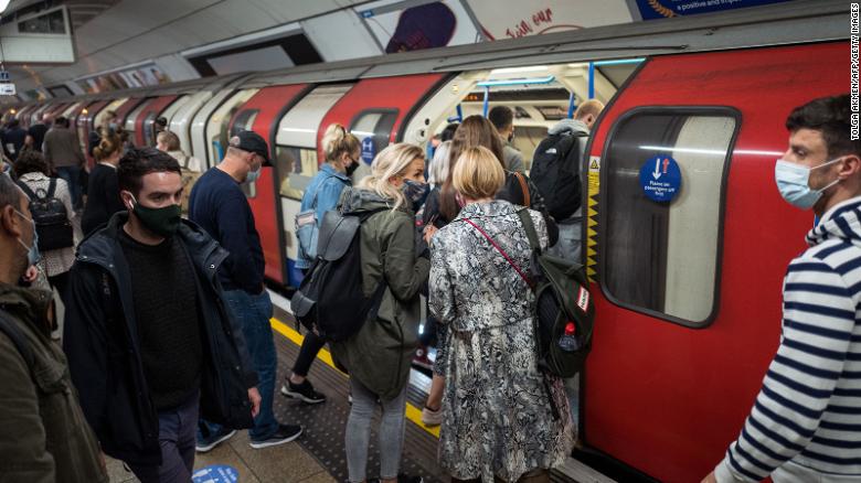 Commuters wearing masks crowd on to a London tube train on September 23. The city will enter the &quot;high&quot; alert level on Saturday, meaning a ban on households mixing indoors.