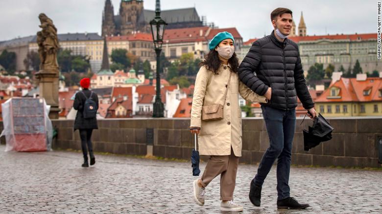 Tourists walk across Prague&#39;s medieval Charles Bridge as the Czech Republic faces a record spike after previously keeping numbers low.