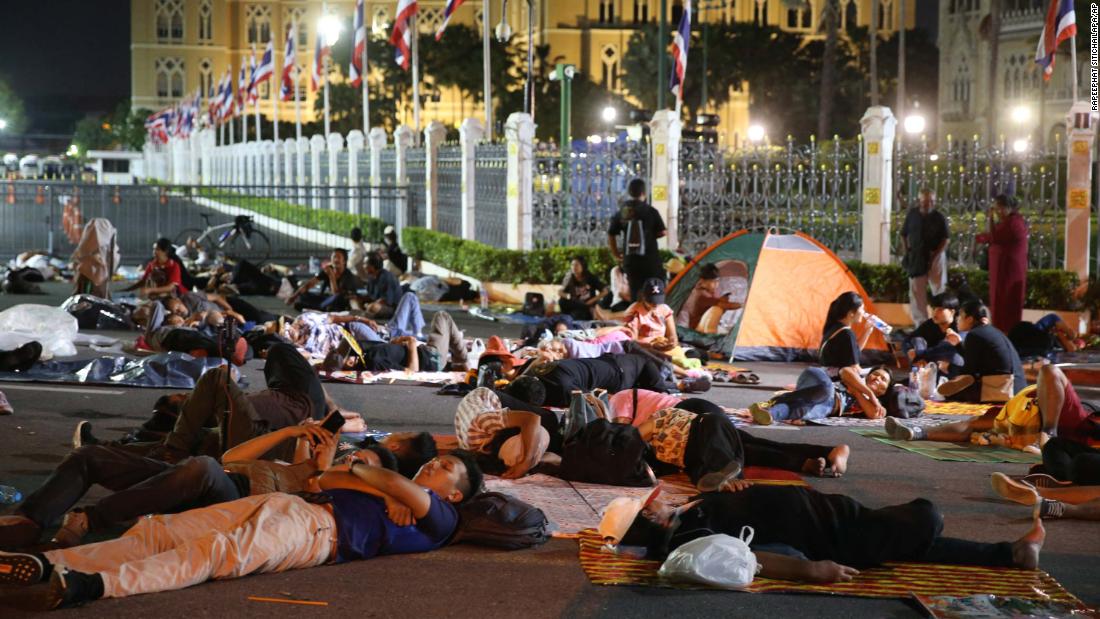 Protesters sleep in front of Government House in Bangkok during a demonstration on October 15.