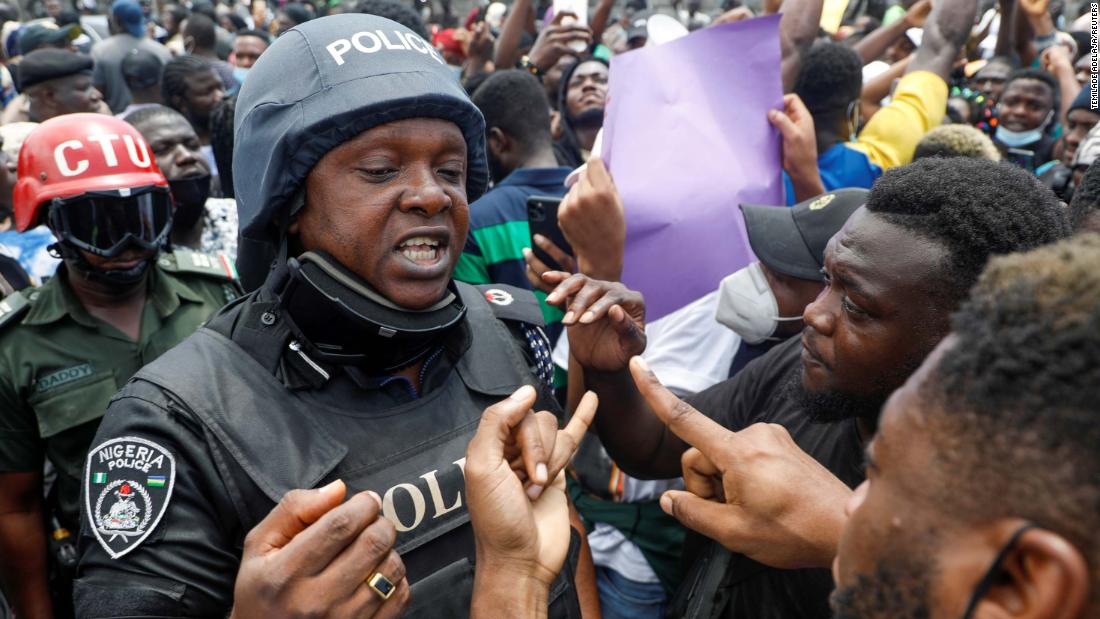 Demonstrators talk to a police officer during a protest in Lagos on October 12.