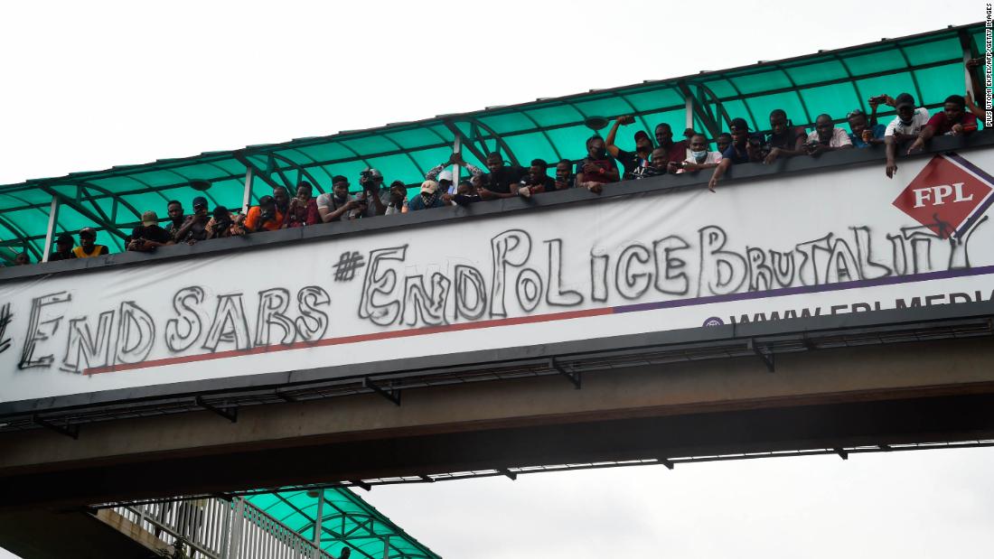 People protest from a pedestrian bridge in Lagos on Thursday, October 15.