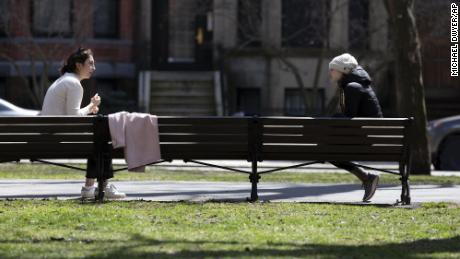 Two women practice social distancing while talking on Commonwealth Avenue Mall, April 4, in Boston. The term &quot;social distancing&quot; has become a commonly used term this year amid the Covid-19 pandemic.
