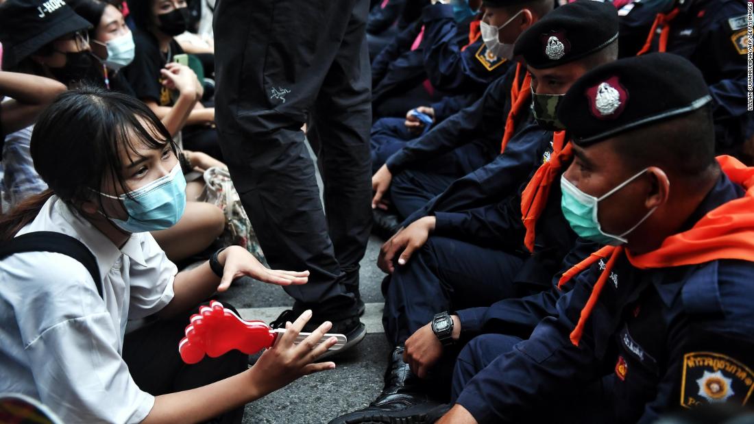 A young pro-democracy protester talks with police during a demonstration in Bangkok on October 15.