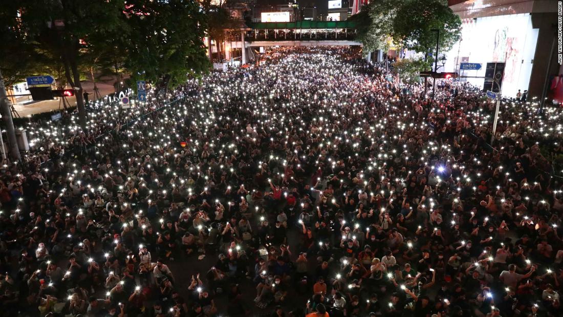 Protesters shine lights from their phones during a demonstration in Bangkok on October 15.