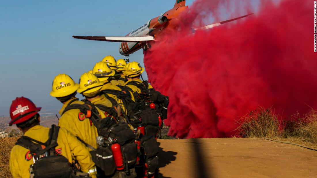 An airplane drops fire retardant on the Bruder Fire in Redlands, California, on Thursday, October 15.