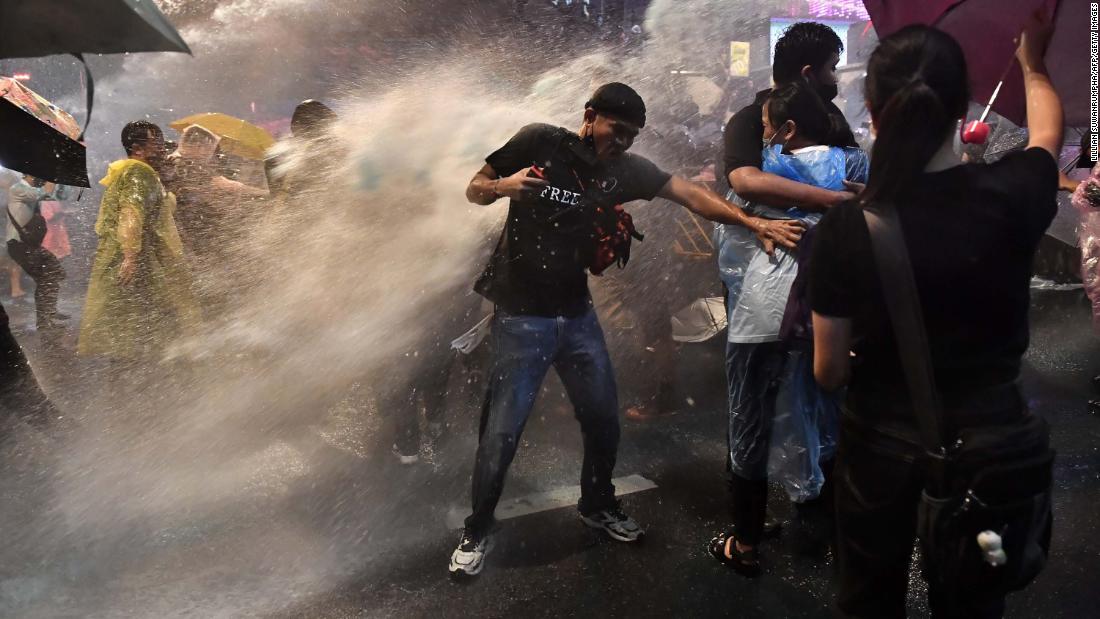 Pro-democracy protesters are blasted by police water cannons on October 16.